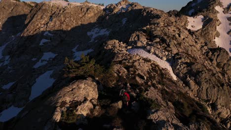 epic aerial view of hikers on a ridge in british columbia alpine backcountry at sunset