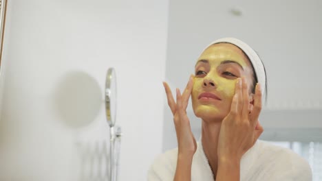 Caucasian-woman-looking-in-mirror-and-doing-make-up-in-bathroom