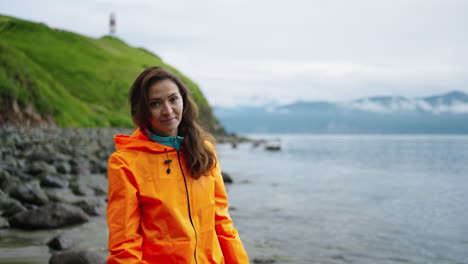 woman in an orange jacket at the beach