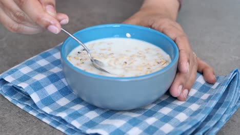 Frauen-Halten-Eine-Schüssel-Frühstücksflocken-Auf-Dem-Tisch