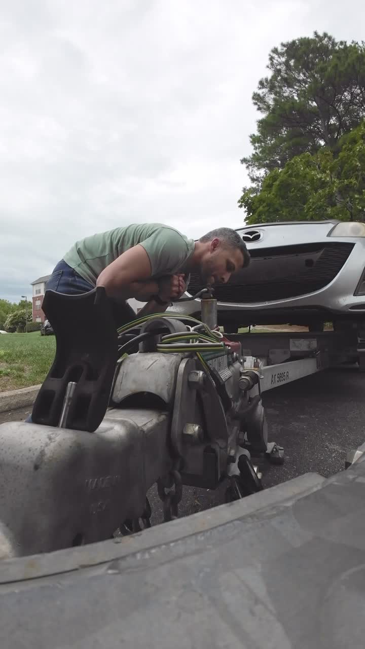 Homem Verificando o Engate de Reboque do Carro
