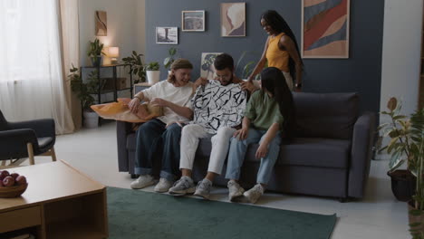 Friends Unwrapping and Trying On a New Shirt in a Living Room