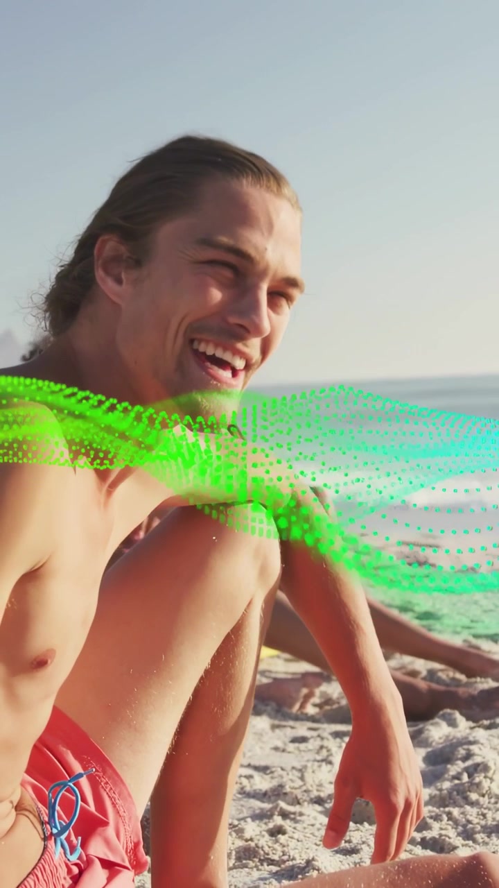 Video verticale: Uomo sulla sabbia che si rilassa, ride e si muove, mentre un'onda tecnologica color verde acqua scorre sui volti.