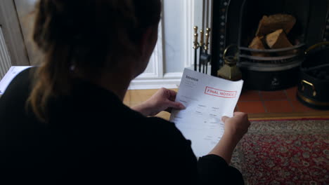 an unrecognizable female opening a debt letter