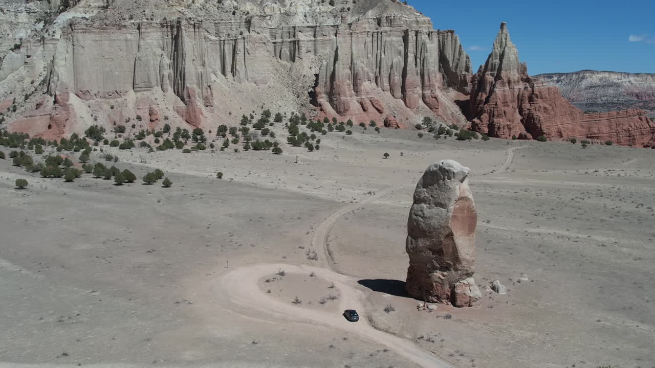 воздушный вид черной машины под песчаной каменной башней в пустынном ландшафте государственного парка кодахром басин, штат юта, сша