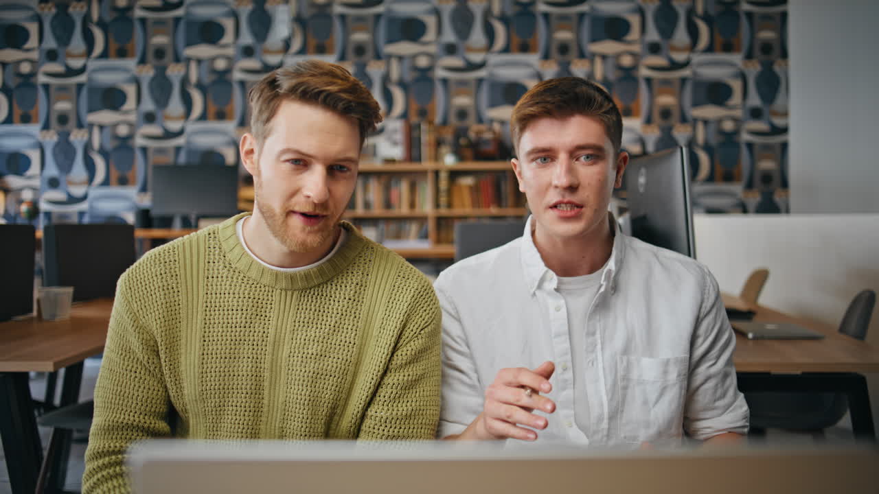Two freelancers brainstorming computer at coworking closeup. Guys talking video