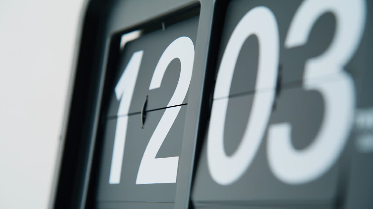 Flip clock shifting numbers in mechanical rhythm indoors closeup. Macro time