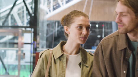 pareja feliz comprando entradas para el cine y pagando con una tarjeta sin contacto en el cine