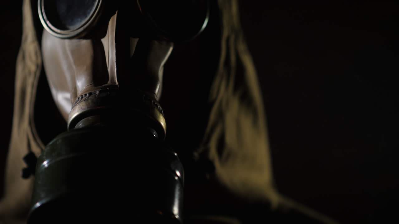 보호복을 입은 남자와 전경에서 방독면 연기