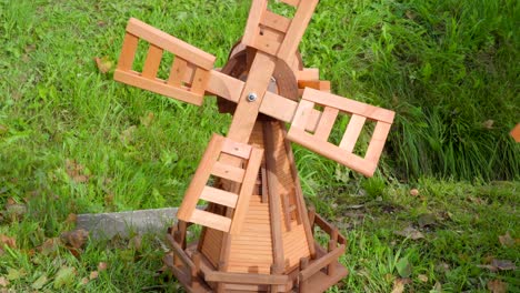 the small wooden windmill toy on the grass lawn