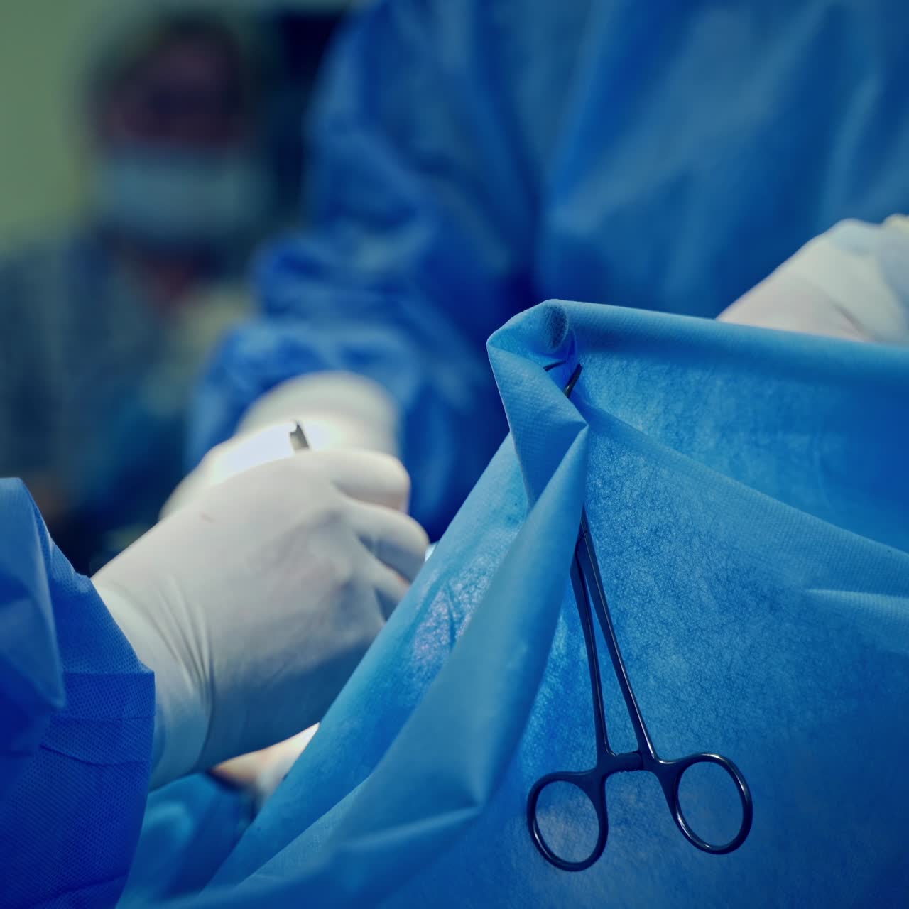 Surgical process by specialists. Doctors' hands in white sterile gloves working with surgical instruments during the operation. Close-up.