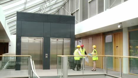 arquitectos con planes que hablan sobre la construcción de un edificio