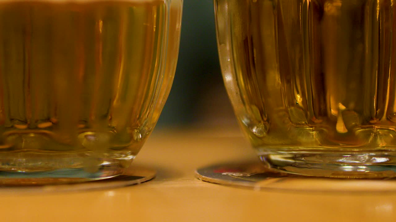 Closeup of foamy lager beer mugs on table in Pilsen, highlighting social and cultural tradition