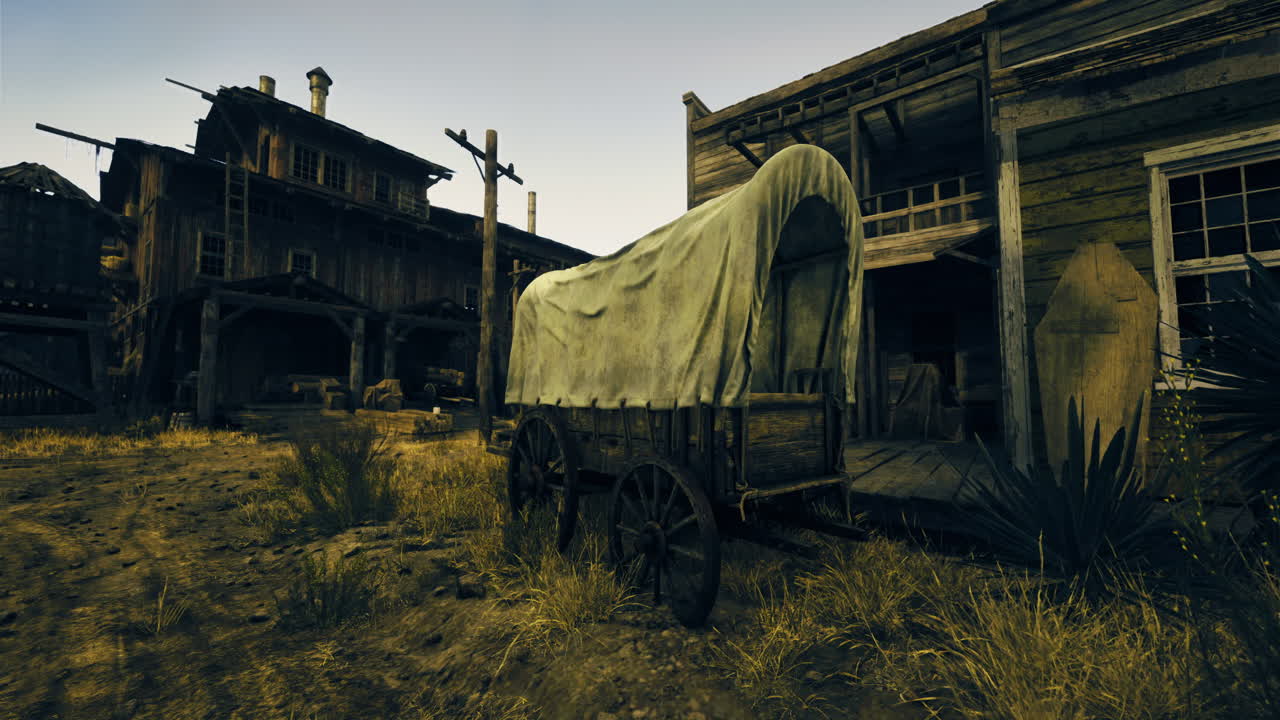 Old wooden wagon near rustic buildings in a dusty setting at sunset