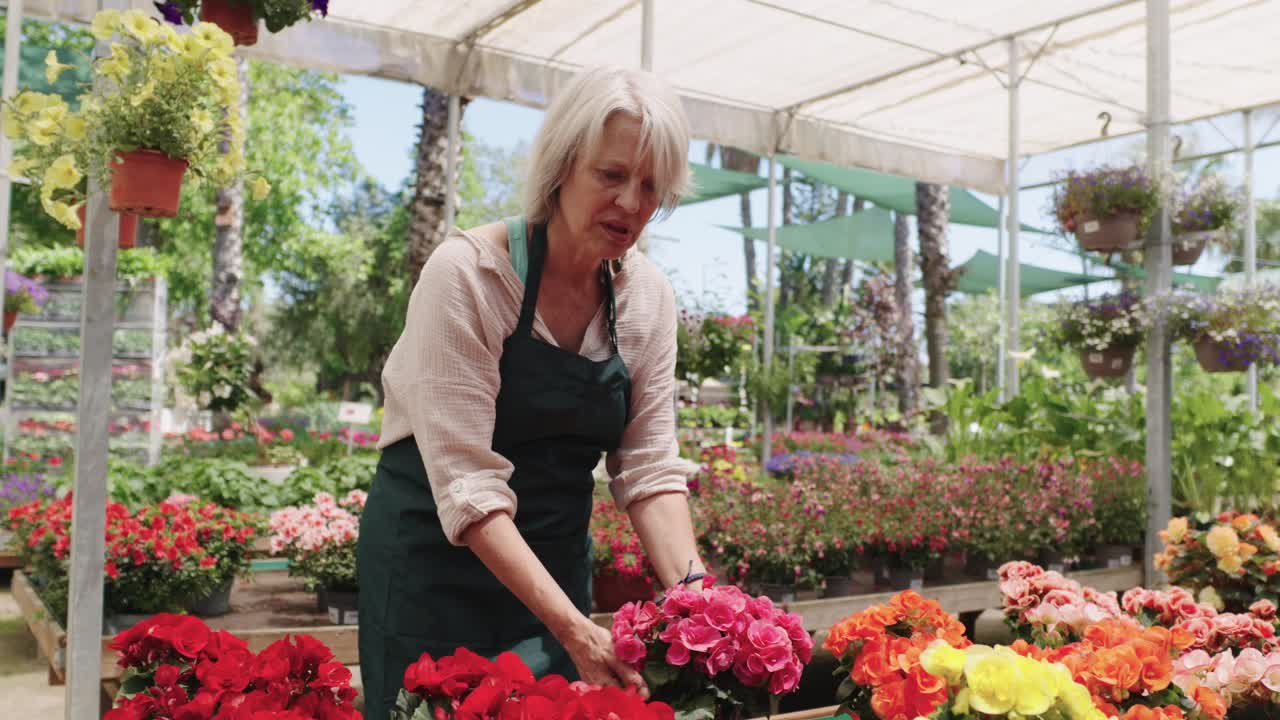 Kvinne som arrangerer blomster i et drivhus