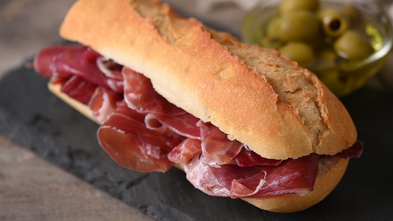 Panino con prosciutto serrano spagnolo su tavolo di legno. Bocadillo de jamón serrano spagnolo