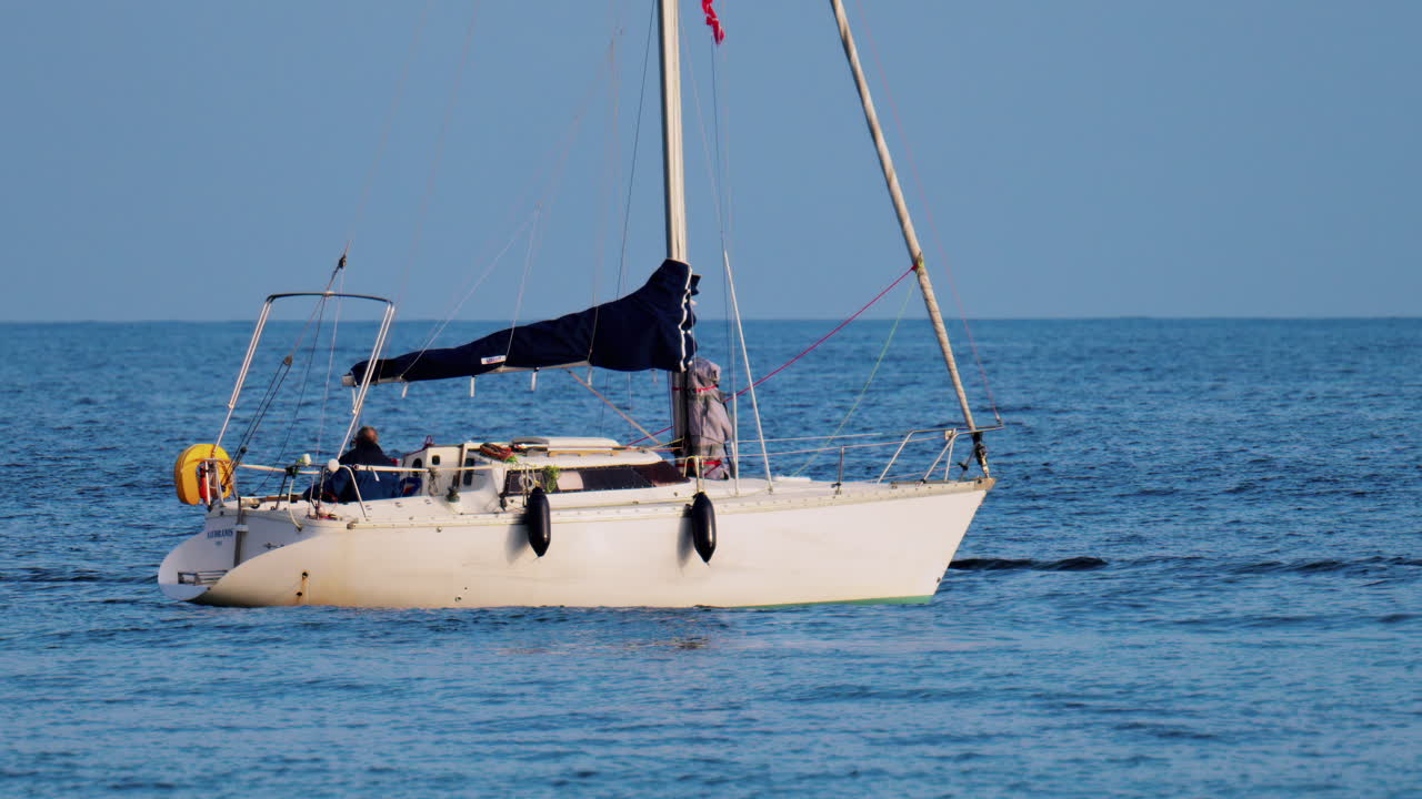 Antibes, France - February 14, 2025: Man on a floating boat on a cloudy day