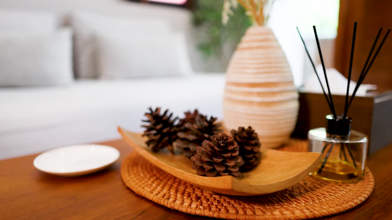 Une main saisit une tasse à café blanche sur une table en bois au décor rustique