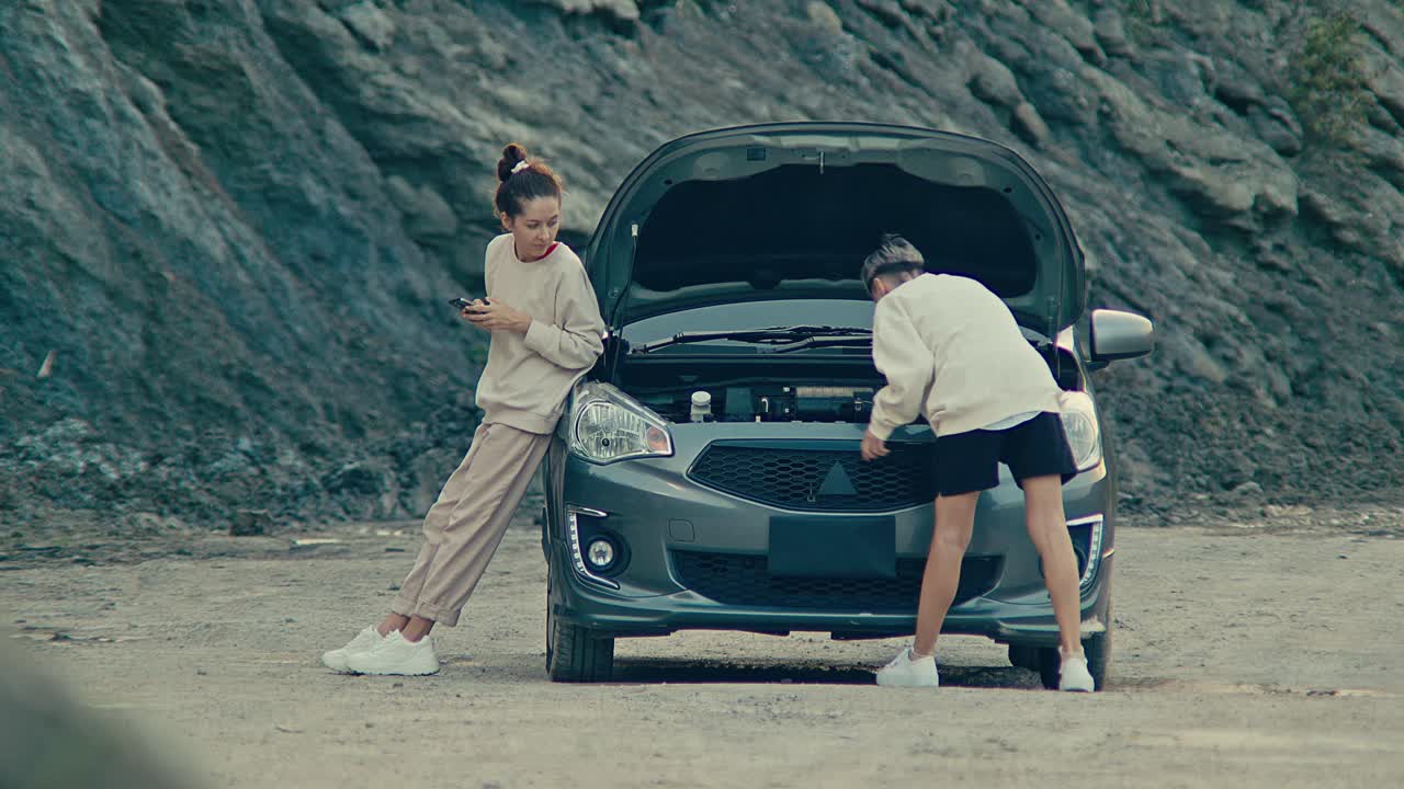 Two women dealing with a car breakdown on a deserted road