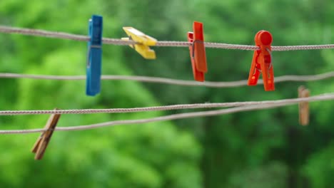 multi-colored clothespins sway in the wind on the clothesline.