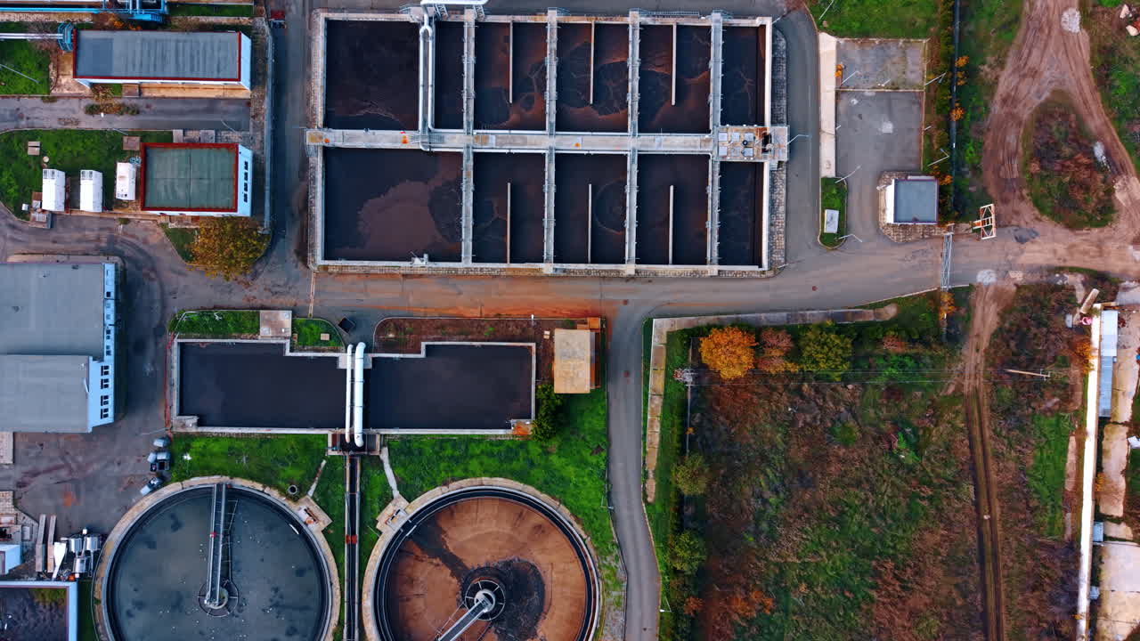 Flight over the territory of modern waste water treatment plant. Multiple reservoirs of diverse shape are being filled with sewage water