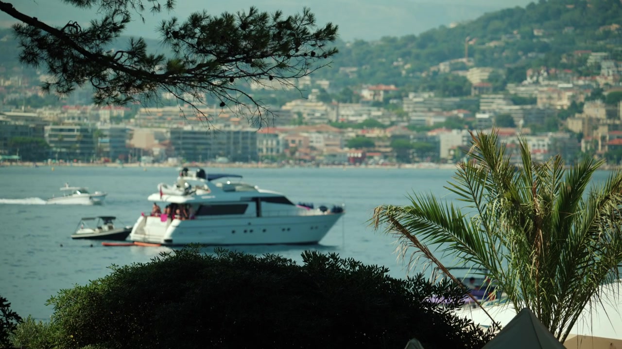 Yacht bianco che naviga in acque calme al largo della splendida costa della Costa Azzurra, un simbolo di lusso e vacanza estiva.