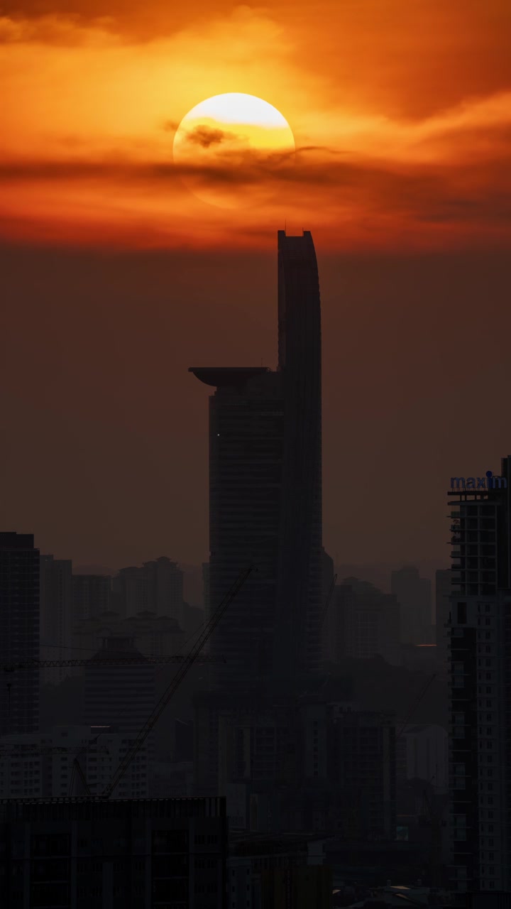 Silhueta do arranha-céu Menara TM contra o céu dourado do pôr do sol em time-lapse ao entardecer