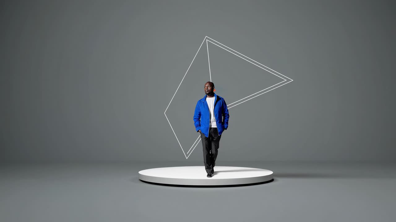 hombre posando frente a una forma de pirámide naranja abstracta