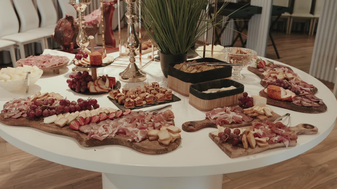 rustic charcuterie boards with cured meats grapes and cheese arranged on round white table