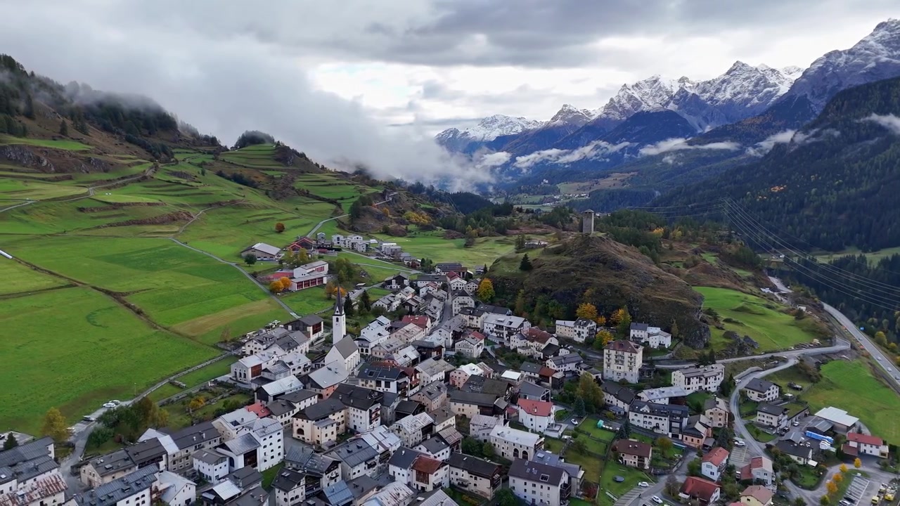 Il pittoresco villaggio svizzero di Ardez annidato tra le montagne sotto cieli nuvolosi, vista aerea