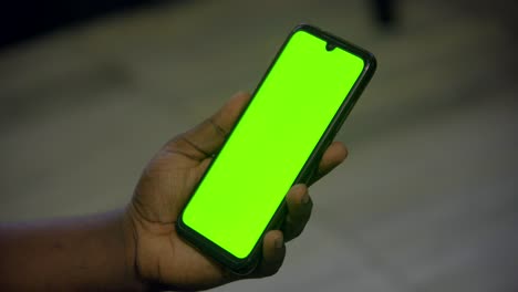 mobile green screen in man hand unlocks and play video in portrait mode
