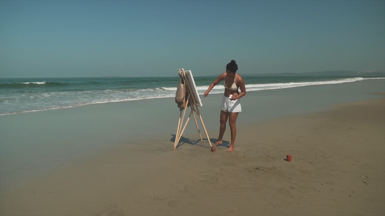 foto larga de un joven artista pintando en una playa soleada, una mujer elegante pinta expresión artística al aire libre