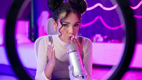 woman recording a podcast with a microphone and ring light