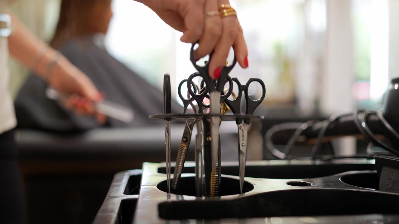 Hairdresser Placing Scissors Back into Holder in Salon