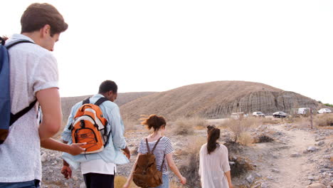 Five-young-adults-hiking-in-Palm-Springs-desert,-follow-shot