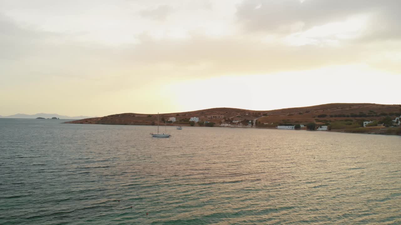 Evocative shot over sea with Paros coast in background. Aerial circling