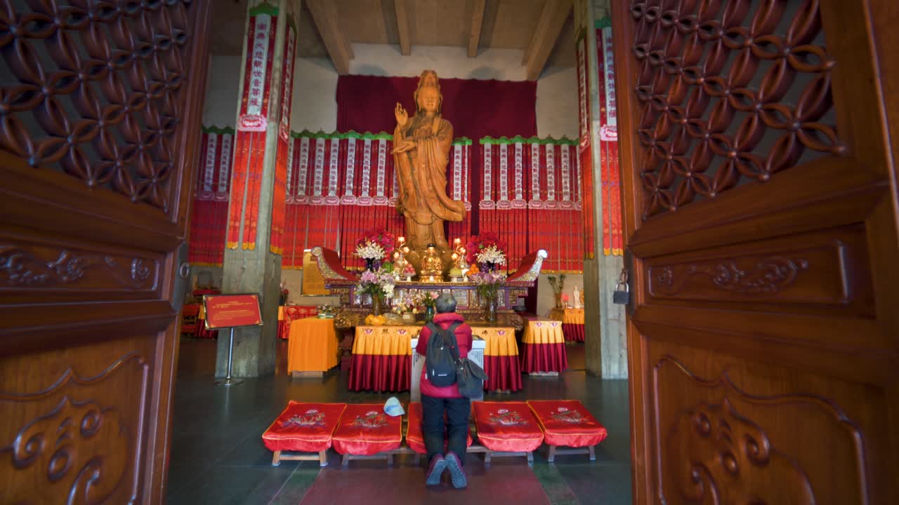 Man prays before goddess Guanyin figure in Jing'an temple in Shanghai, China.
