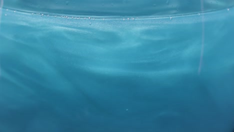 primer plano de líquido azul en un vaso
