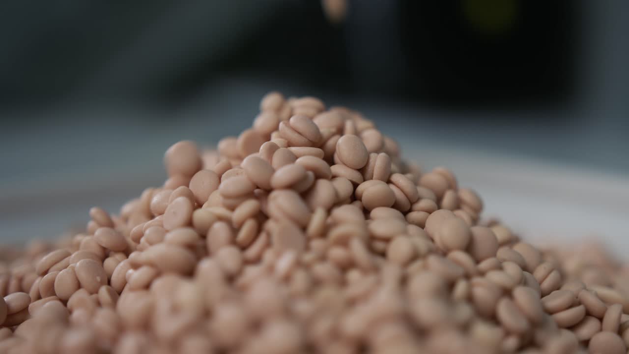 Slow motion shot of granules for milling machine coolant falling down and creating a pile of granules