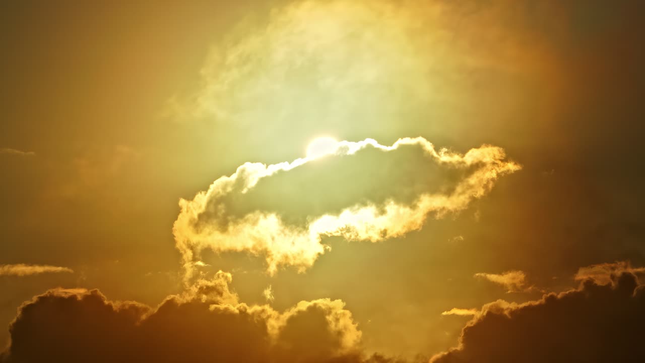 Céu dramático de pôr do sol dourado com raios de sol por trás de silhuetas de nuvens escuras