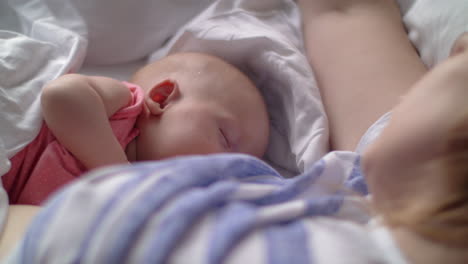 Woman-breasfteeding-baby-lying-in-bed