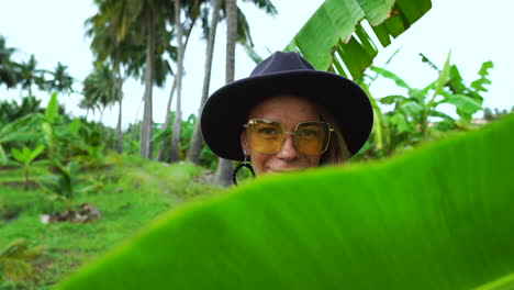 Beautiful-Woman-With-Banana-Leaf-On-The-Plantation---medium-shot