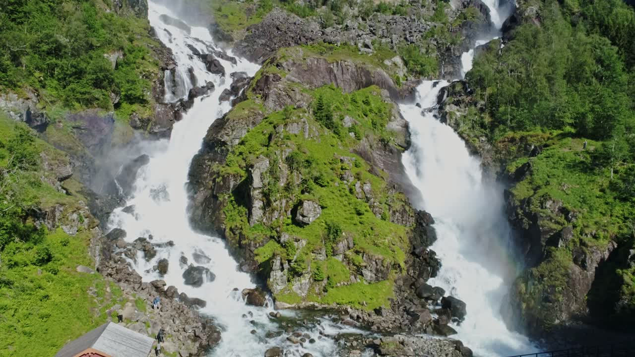 Drone Ascending Over Norway Låtefoss waterfall, powerful cascades, lush greenery