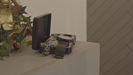 Close-up-of-dark-skinned-man-grabbing-luxury-watch-from-box-on-dresser