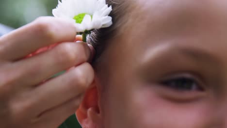 mother putting flower in daughters hair