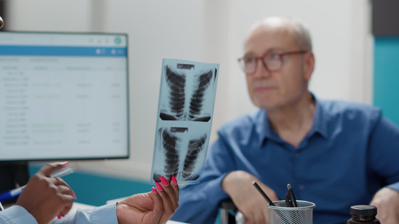 Medical consultation with elderly patient reviewing x-ray results