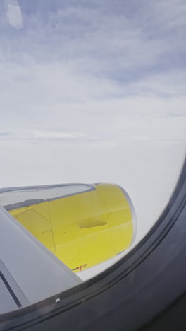 view from a plane window of the sky with the wing of the plane in shot in vertical