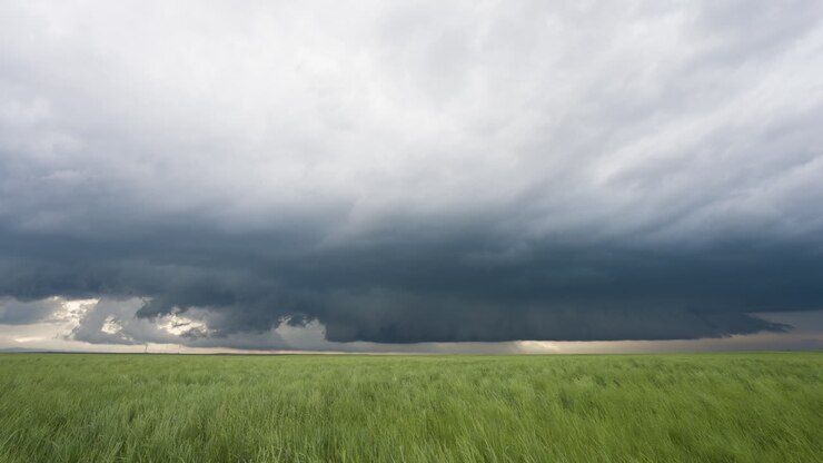 Mørke stormskyer udvikler sig over smukt landbrugsland i foråret