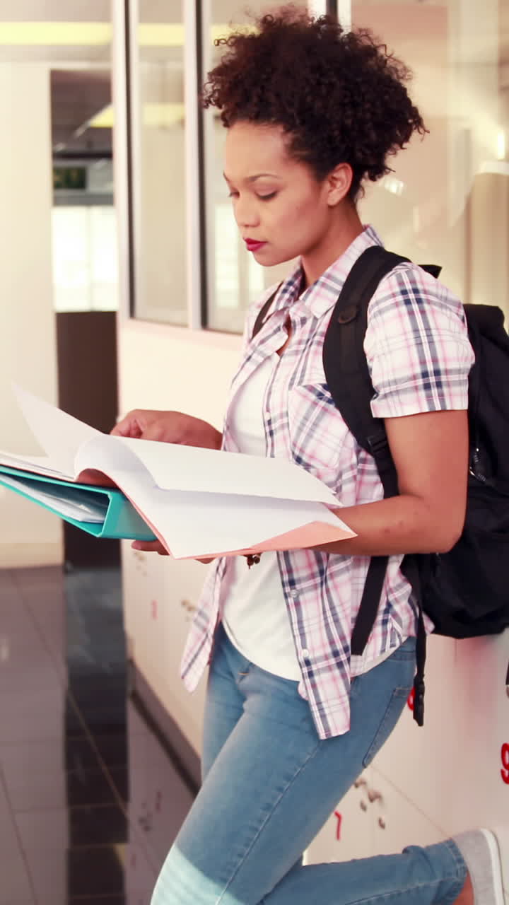 estudiante bonita revisando y sonriendo a la cámara con los pulgares hacia arriba