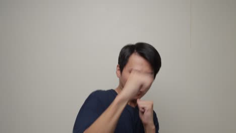 중국인 남자가 색 배경에 대해 방어적인 입장을 취하고 있습니다.